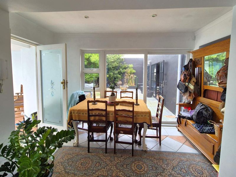 Dining area featuring tiled flooring and large sliding glass doors providing direct access to the rear patio and garden.