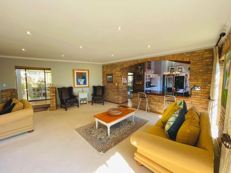 Spacious open-plan living area featuring exposed brick accents, a breakfast bar connecting to the kitchen, and sliding doors leading to an outdoor patio.