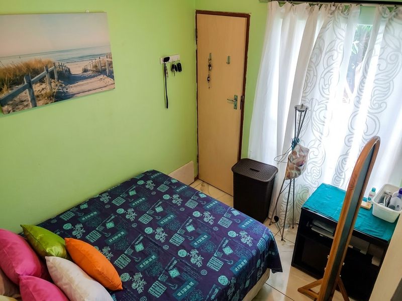 A compact bedroom featuring tiled flooring and a standard internal door, providing a functional living space.