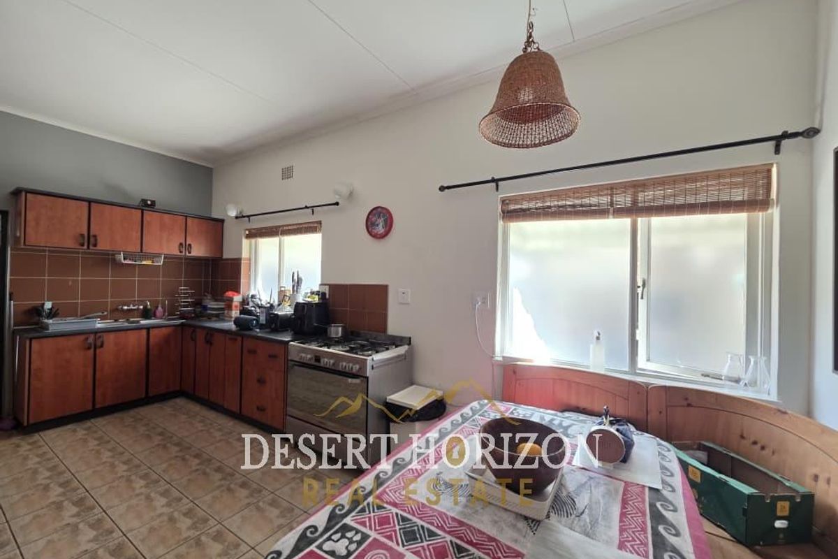 A functional kitchen featuring wooden cabinetry, tiled backsplash, and a built-in stove, offering a practical layout for daily meal preparation.