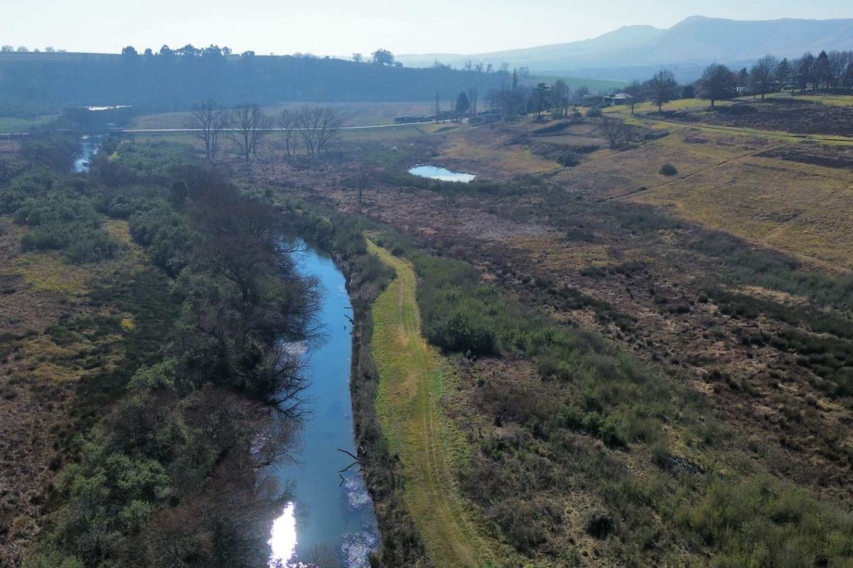 An aerial view of the vacant residential land featuring a natural river and expansive rural landscape.