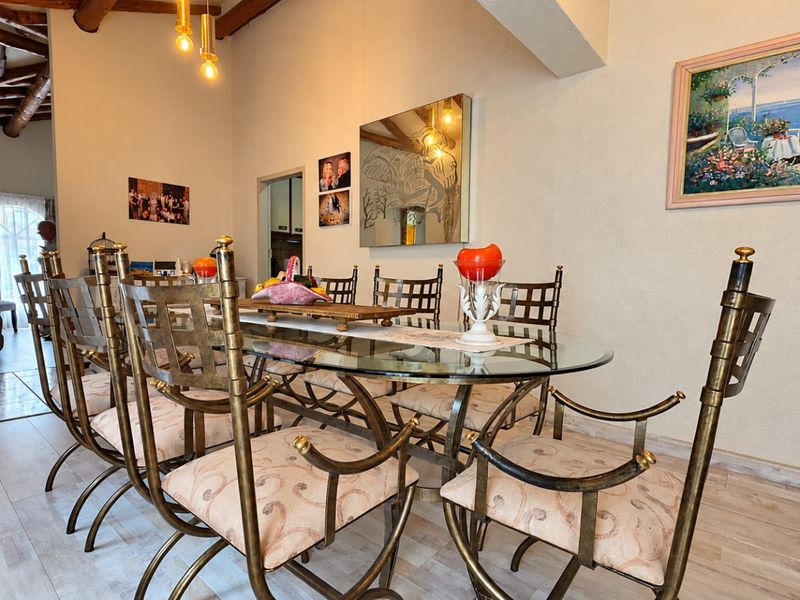 Dining room featuring exposed timber ceiling beams, tiled flooring, and a spacious layout suitable for family gatherings.
