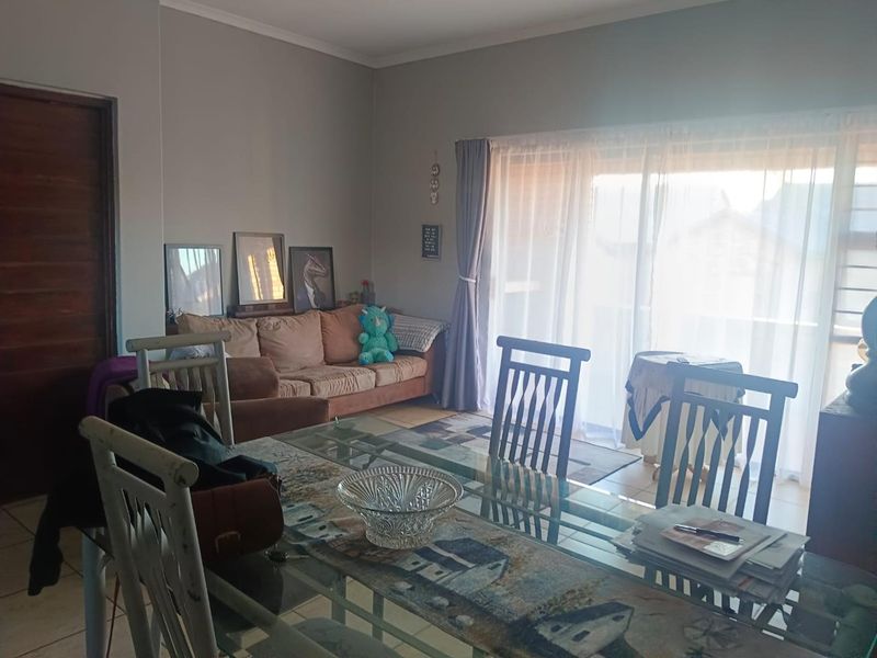 Open plan living and dining area featuring tiled flooring and a large sliding glass door providing access to the exterior.