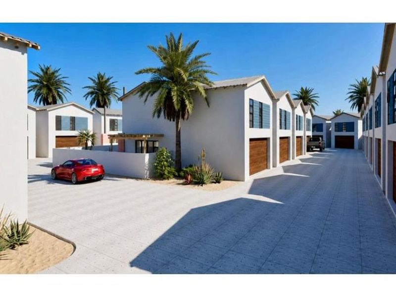 A modern townhouse complex featuring a paved driveway, multiple garage doors, and clean architectural lines in a well-maintained residential setting.