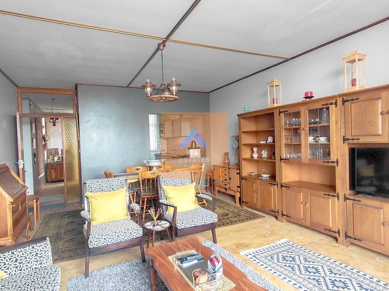 Open plan living and dining area featuring dated finishes and built-in cabinetry, offering a spacious layout with potential for modernization.