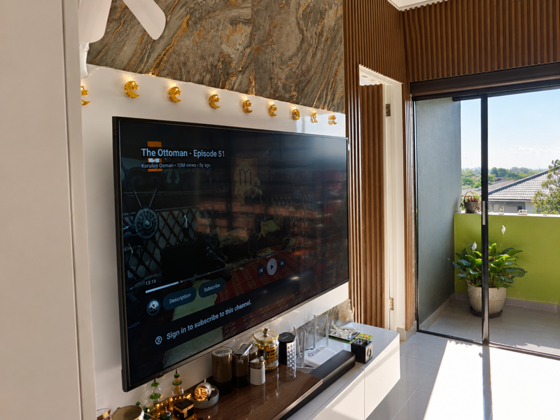Modern living room featuring a marble-effect feature wall, timber slat accents, and direct access to a private balcony through sliding glass doors.