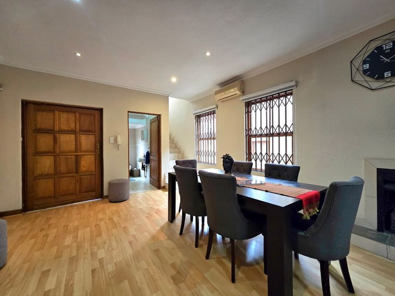 Open plan living and dining area featuring laminate flooring, recessed lighting, split-system air conditioning, and secure window treatments.