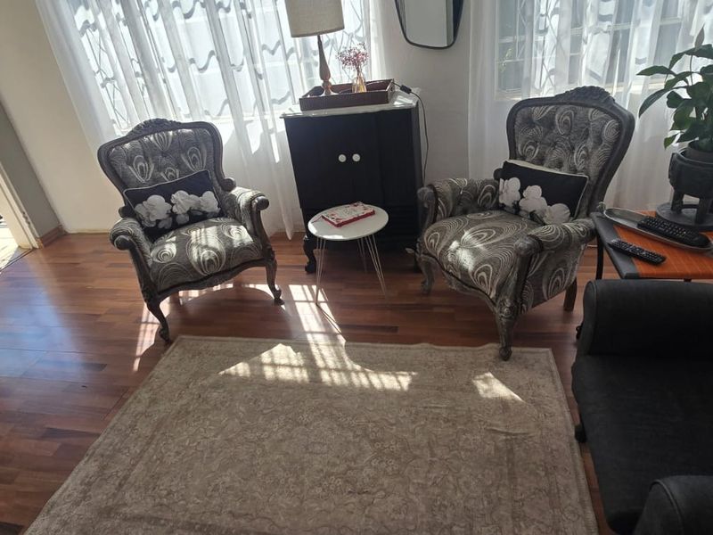 A cozy living room featuring warm hardwood flooring and a sliding glass door providing access to an outdoor patio area.