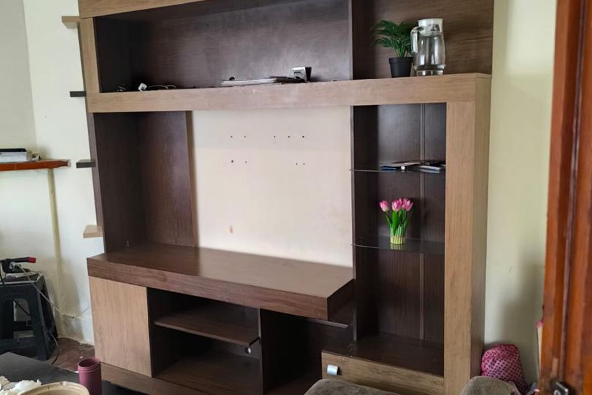 A living room featuring a large, built-in wooden media wall unit with integrated shelving and storage compartments.