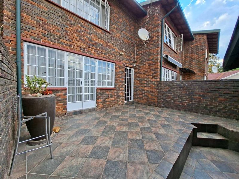 A private rear patio area featuring durable tiled flooring and a classic face brick exterior finish, providing a low-maintenance outdoor space.