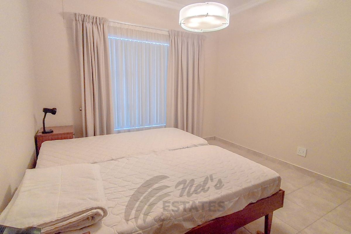 A functional bedroom featuring tiled flooring, neutral wall finishes, and a central light fixture, providing a clean and simple living space.