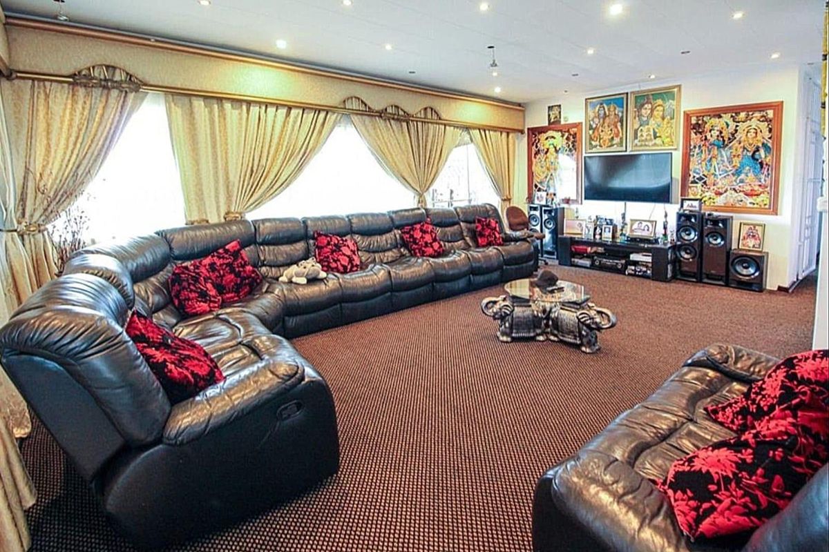 Spacious living room featuring wall-to-wall carpeting and recessed downlighting, offering a large area for comfortable seating and entertainment.