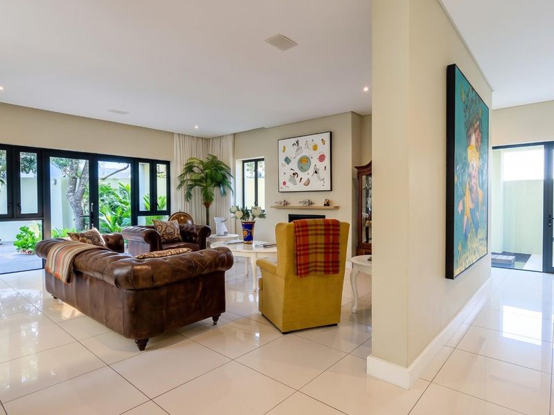 Spacious living room featuring polished porcelain floor tiles, recessed lighting, and large aluminium sliding doors providing seamless access to the outdoor patio area.