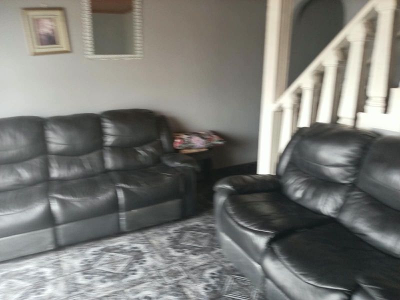 A living room area featuring a staircase with a white balustrade, finished with patterned flooring.