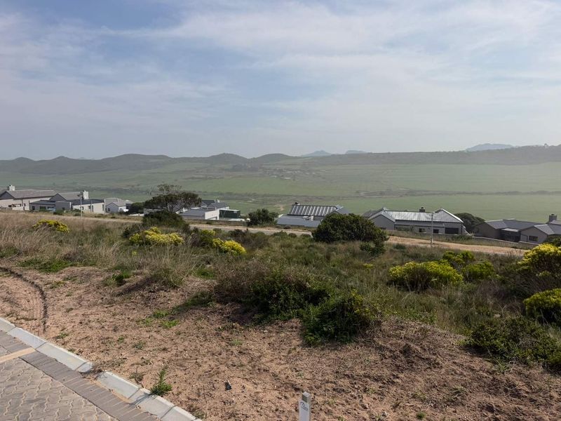 A scenic elevated view overlooking a residential estate with surrounding natural landscape and distant hills.