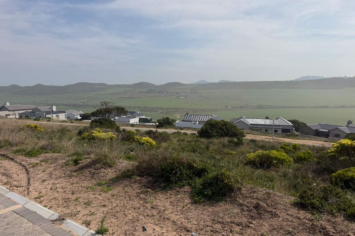 A scenic elevated view overlooking a residential estate with surrounding natural landscape and distant hills.