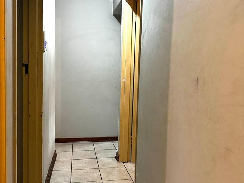 A functional hallway featuring tiled flooring and neutral wall finishes, providing access to multiple rooms within the apartment.