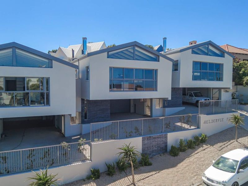 Modern cluster development featuring contemporary architectural design, large windows, integrated garages, and secure perimeter fencing in a well-maintained estate setting.