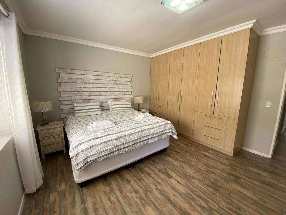 Ground floor, bedroom 1 with built-in cupboards, TV and en-suite bathroom. 