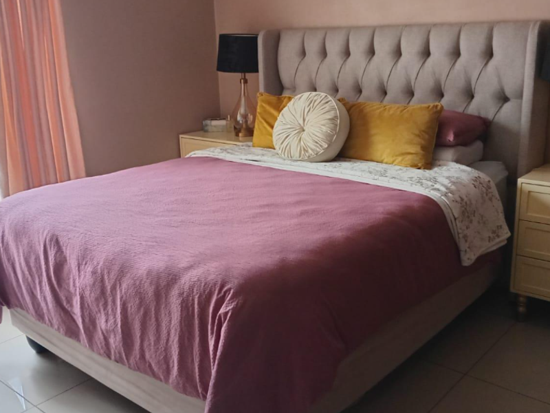 A well-maintained bedroom featuring neutral wall tones and tiled flooring, providing a comfortable and functional living space.