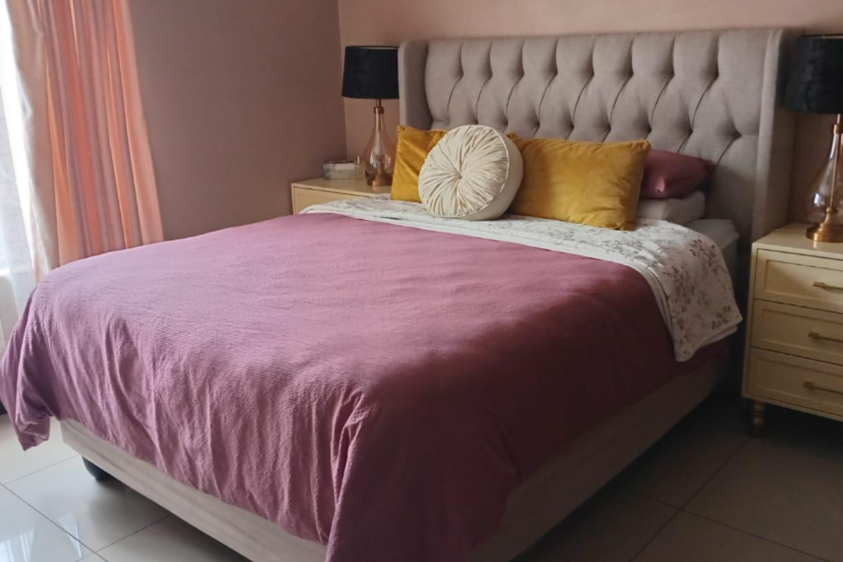 A well-maintained bedroom featuring neutral wall tones and tiled flooring, providing a comfortable and functional living space.
