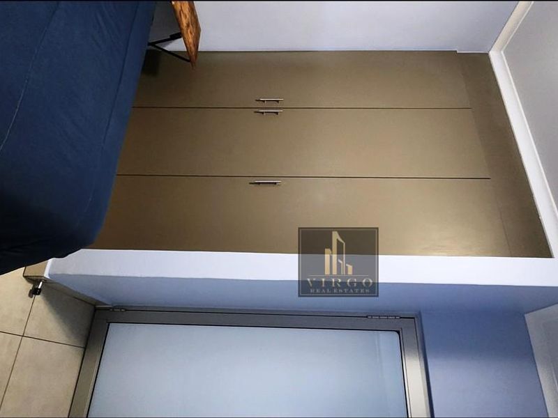 A bedroom featuring built-in cupboards and tiled flooring, presented in a top-down perspective.