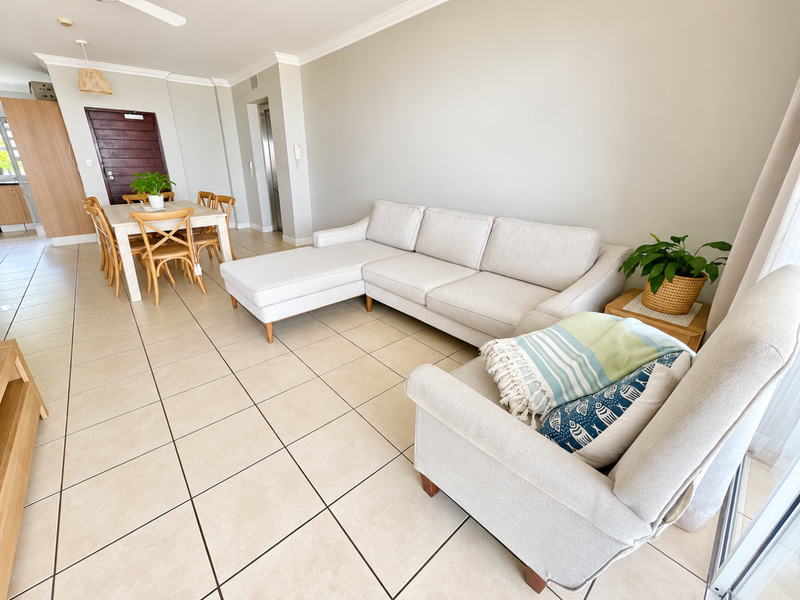 Spacious open-plan living and dining area featuring neutral ceramic floor tiles, coved cornicing, and a ceiling fan, creating a bright and airy atmosphere.