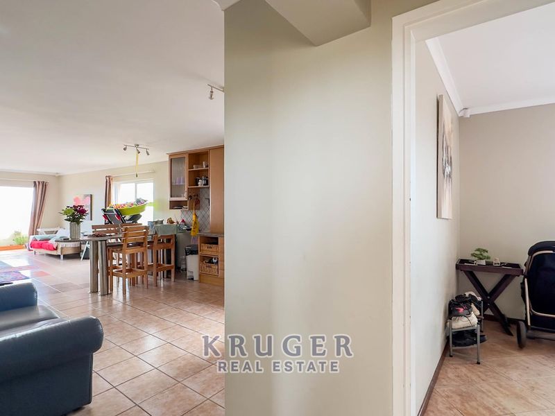 Open plan living and kitchen area featuring tiled flooring and sliding glass doors leading to an outdoor space.