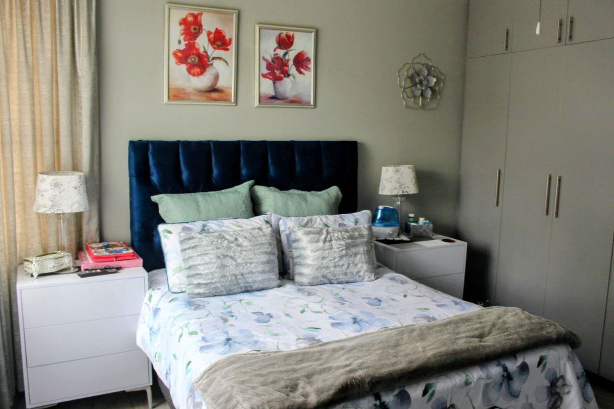 A well-maintained bedroom featuring built-in floor-to-ceiling cabinetry and neutral wall finishes.
