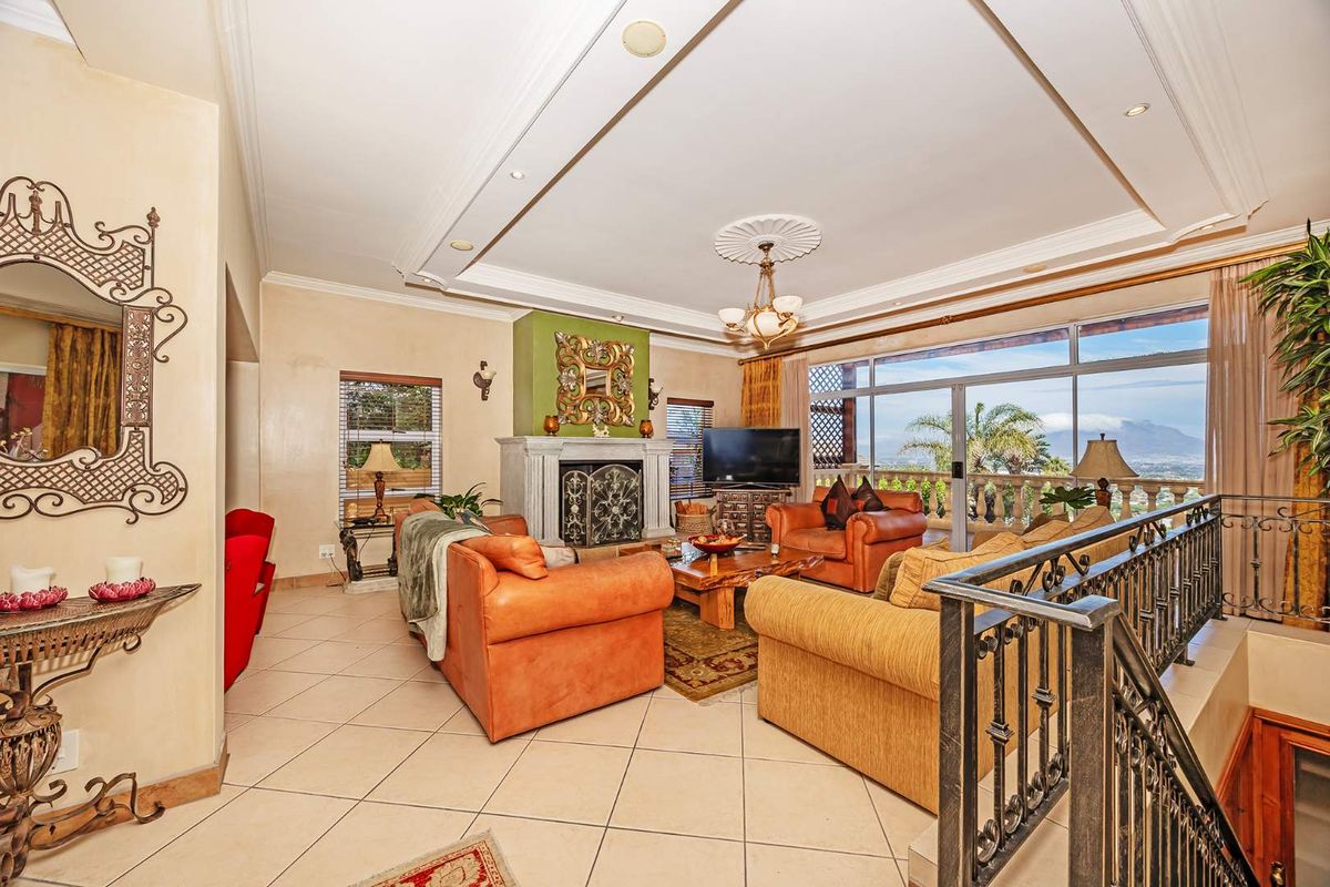 Spacious living room featuring a stone fireplace, recessed ceiling details, tiled flooring, and large sliding glass doors opening to a scenic balcony.
