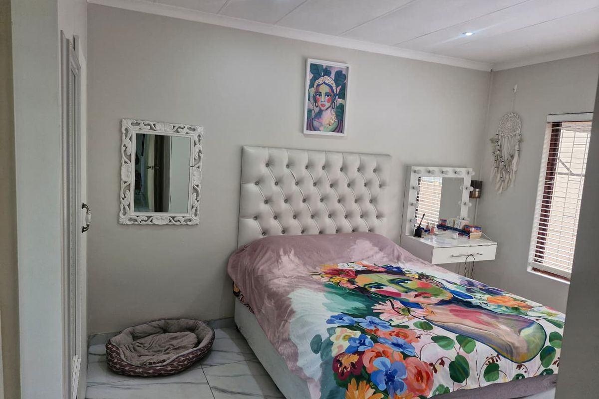 A well-maintained bedroom featuring tiled flooring, recessed downlighting, and venetian blinds, offering a clean and functional living space.