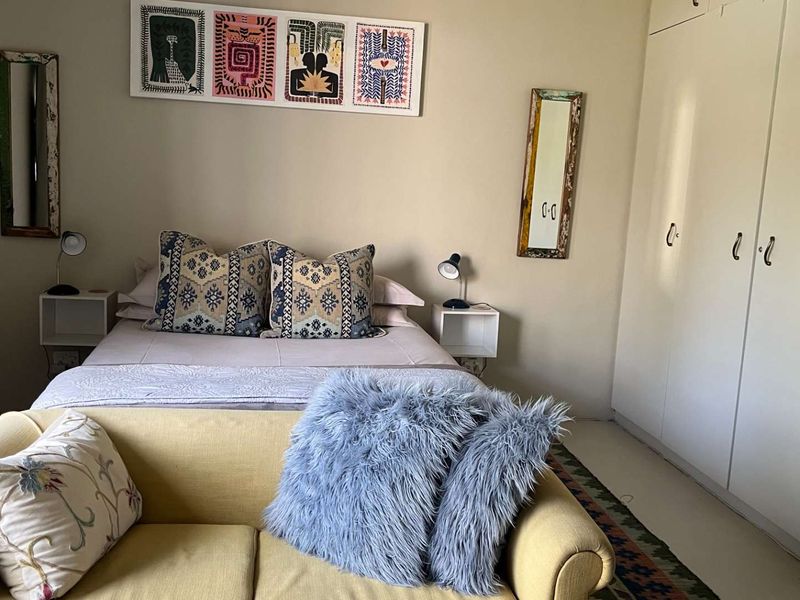 A bedroom featuring neutral walls and integrated built-in cupboards, providing functional storage space within the cottage.