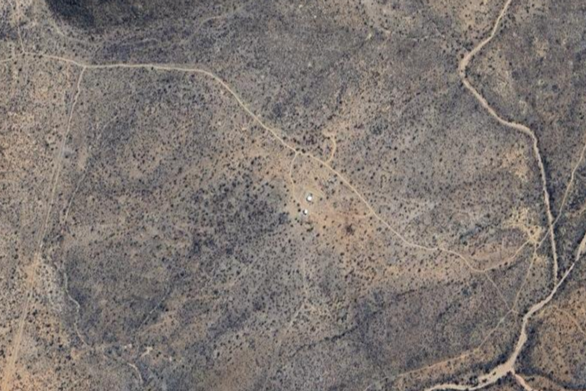 Aerial view of a large, undeveloped small holding property featuring natural scrubland terrain and existing dirt access tracks.