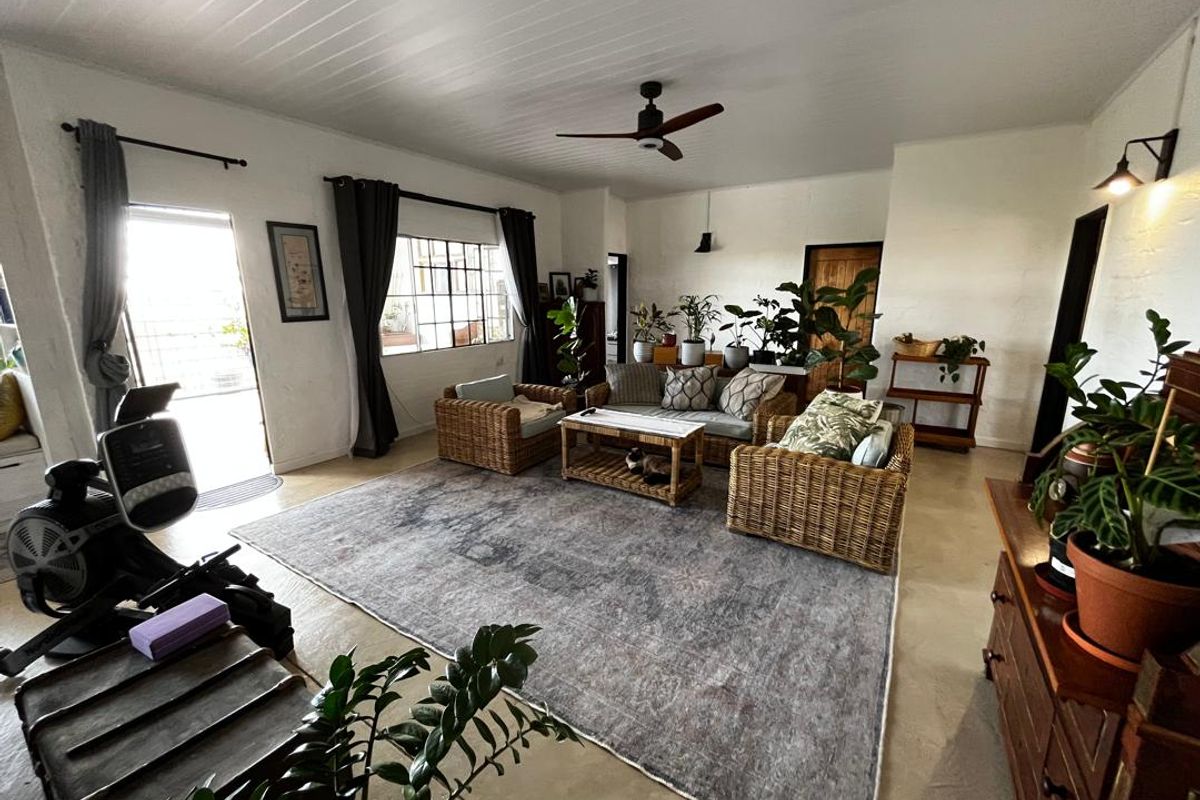 Spacious living room featuring concrete flooring, a tongue and groove ceiling, and large steel-framed windows providing natural light.