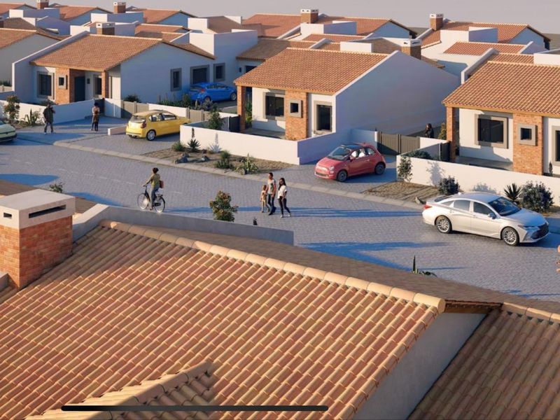 An aerial perspective of a residential estate featuring multiple detached houses with tiled roofs and paved street access.