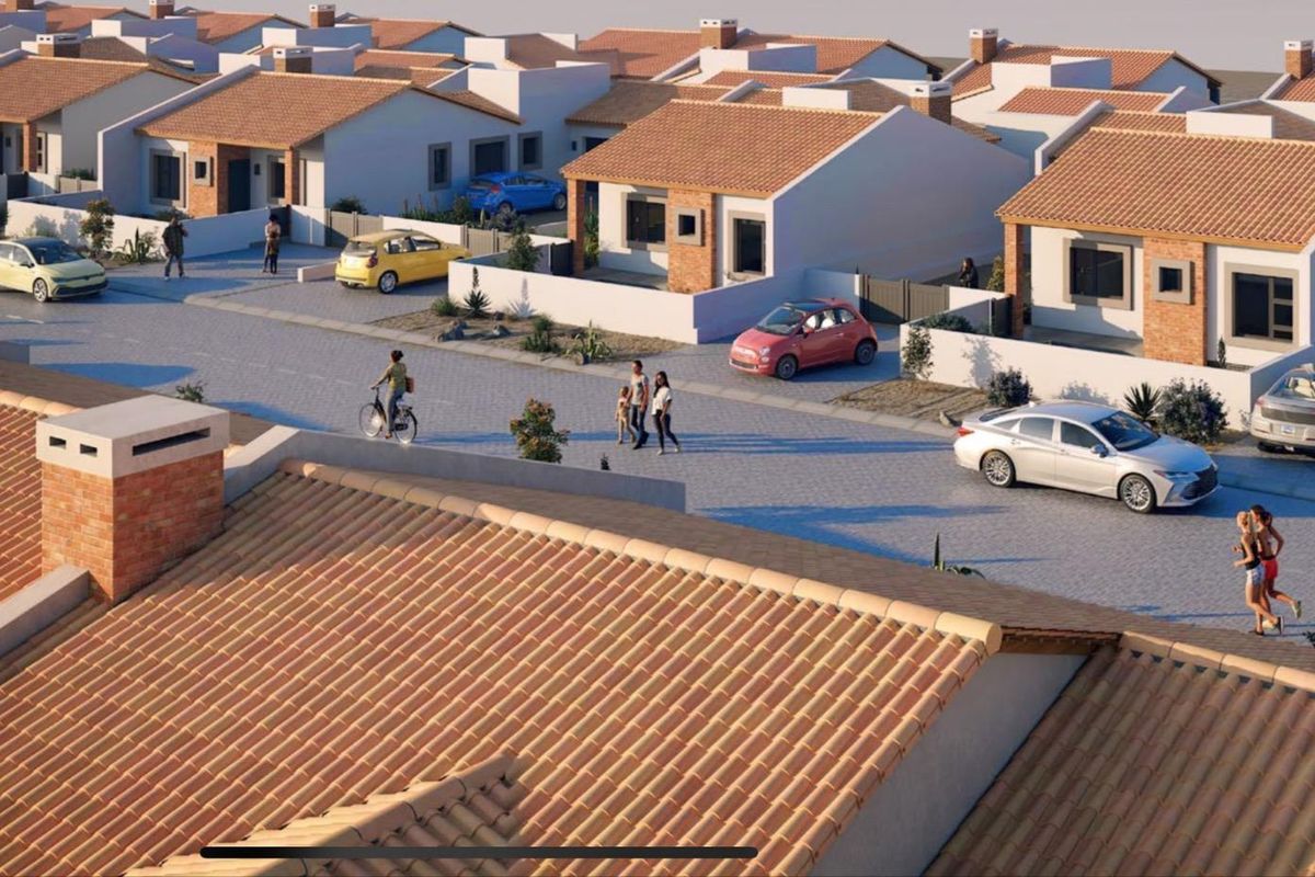 An aerial perspective of a residential estate featuring multiple detached houses with tiled roofs and paved street access.