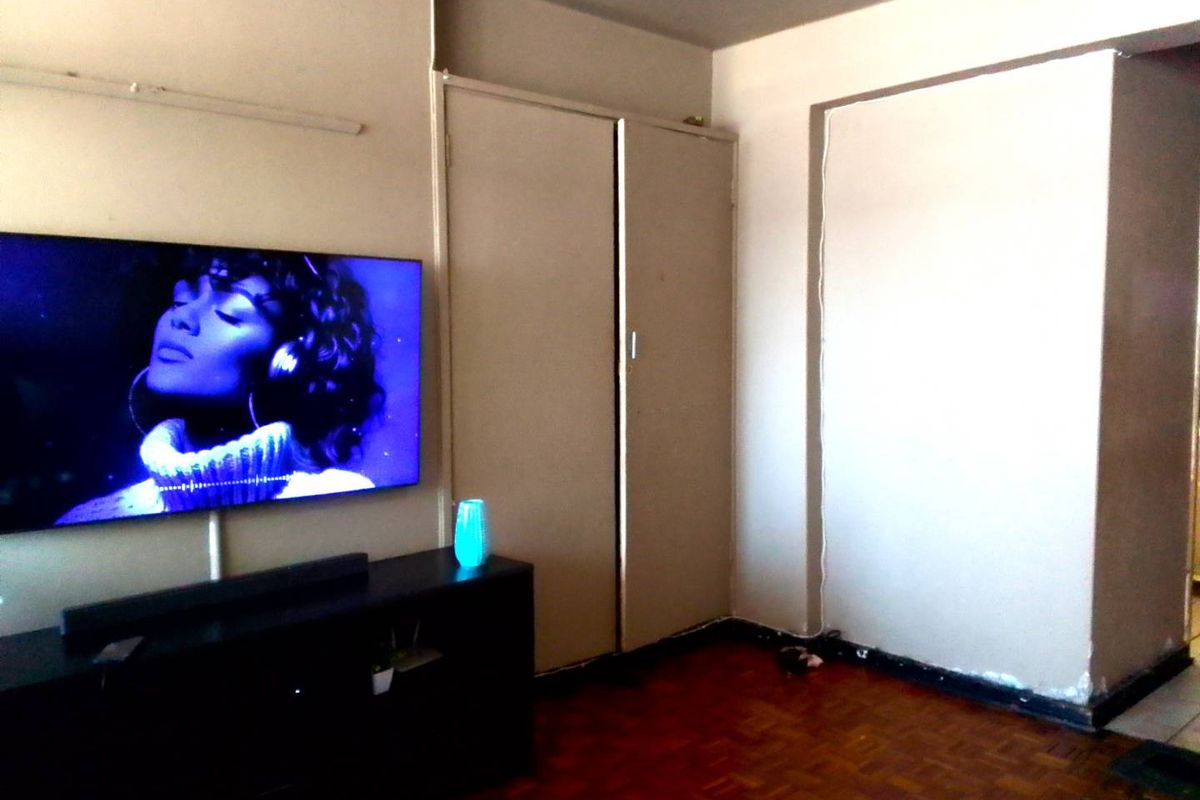 Bedroom featuring parquet flooring and built-in cupboards, requiring cosmetic updates to the walls and skirting boards.