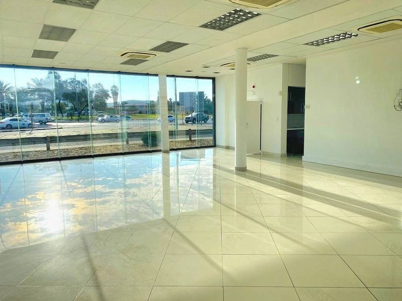 Spacious open-plan retail unit featuring floor-to-ceiling glass frontage, polished tile flooring, suspended ceilings, and integrated air conditioning.