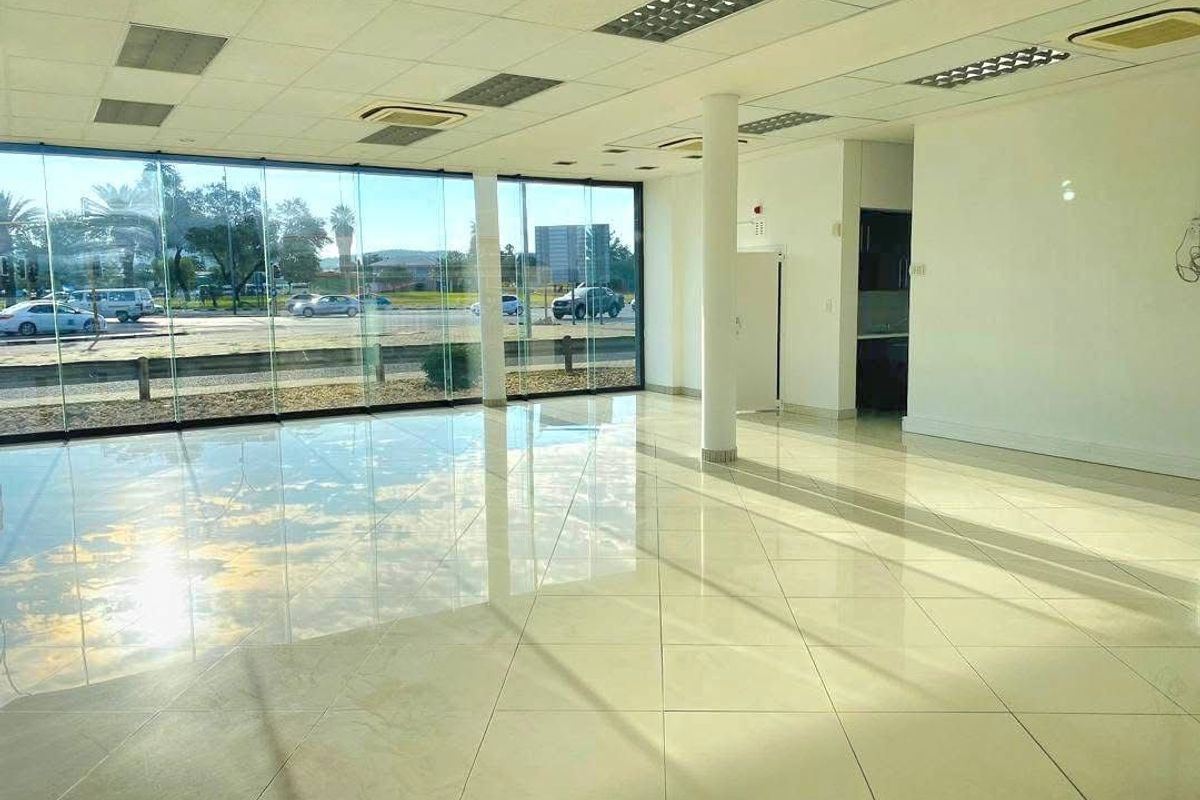 Spacious open-plan retail unit featuring floor-to-ceiling glass frontage, polished tile flooring, suspended ceilings, and integrated air conditioning.