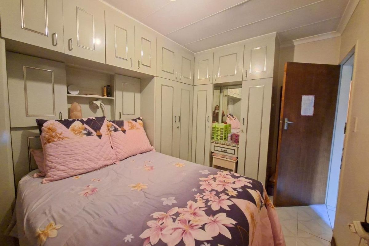 A bedroom featuring extensive built-in cabinetry providing ample storage, tiled flooring, and a coved ceiling.