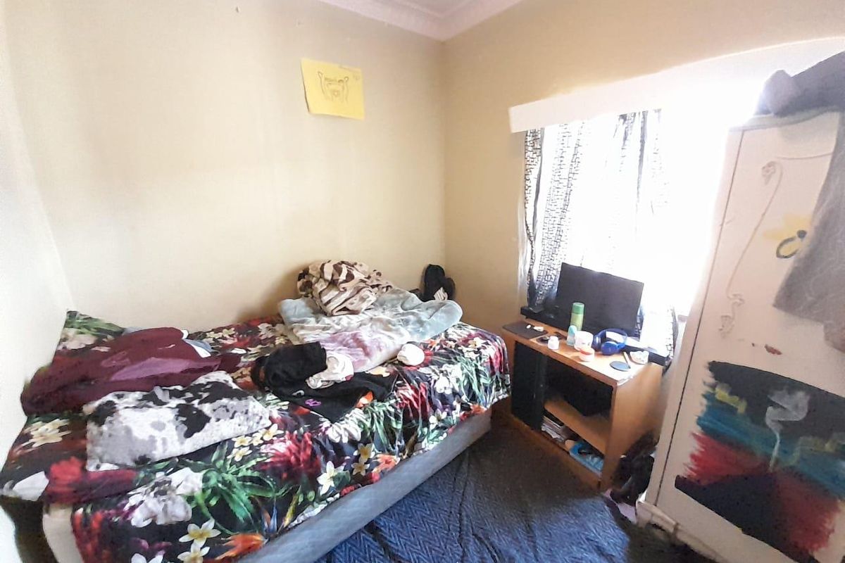 A compact bedroom featuring standard wall finishes and ceiling cornice, requiring cosmetic updates to improve its overall presentation and appeal.