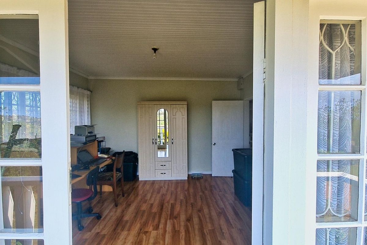 A bedroom featuring laminate flooring, a beaded ceiling, and timber-framed glass doors providing natural light and access to the exterior.