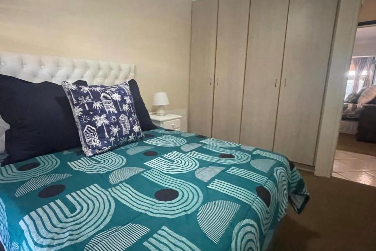 A bedroom featuring built-in cupboards and carpeted flooring, offering a functional space with neutral wall finishes.