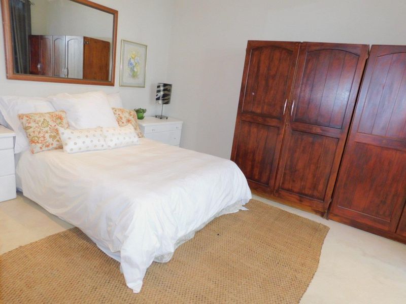A functional bedroom featuring neutral tiled flooring and ample space for bedroom furniture.