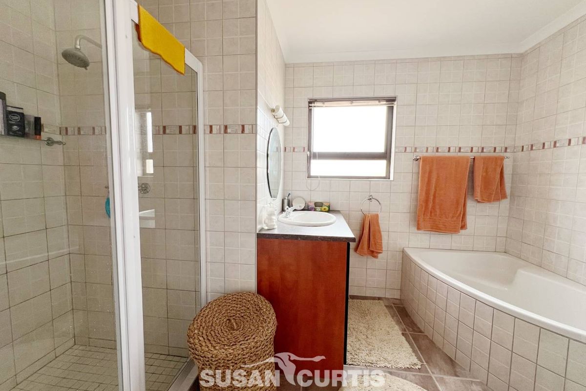 A functional bathroom featuring a separate shower enclosure, a built-in bathtub, and a vanity unit with a basin.