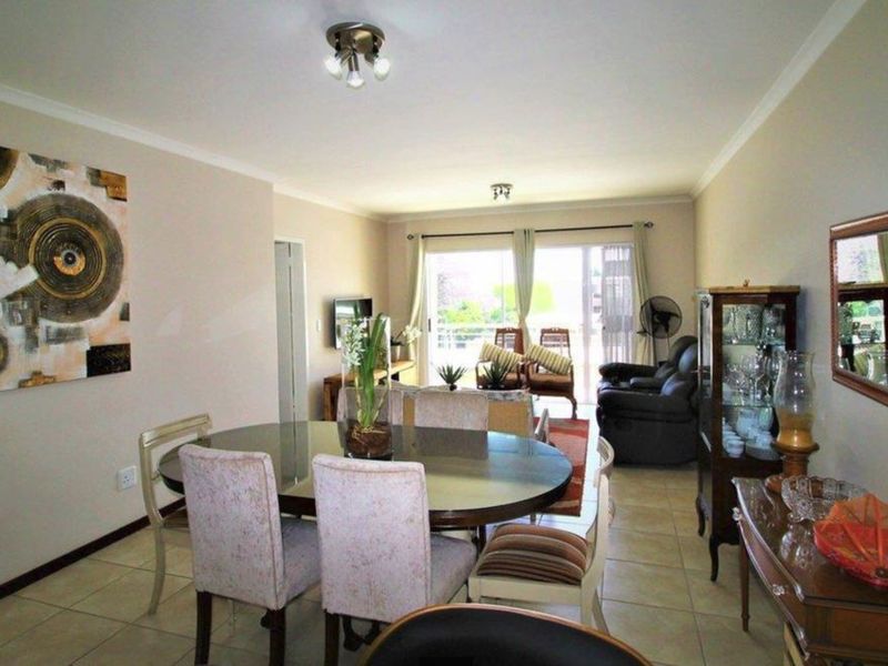 Open plan living and dining area featuring tiled flooring and a sliding glass door leading to an outdoor space.