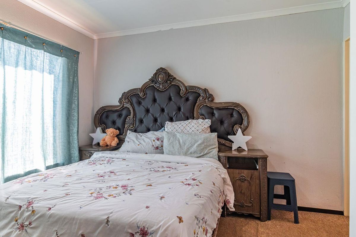 A standard bedroom featuring carpeted flooring and coved ceiling detailing, providing a functional space for rest.