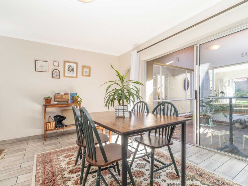 A bright dining area featuring tiled flooring and large sliding glass doors that provide seamless access to the outdoor patio space.