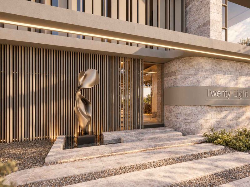 Modern architectural front entrance featuring premium stone cladding, timber slat detailing, integrated lighting, and a sophisticated water feature.