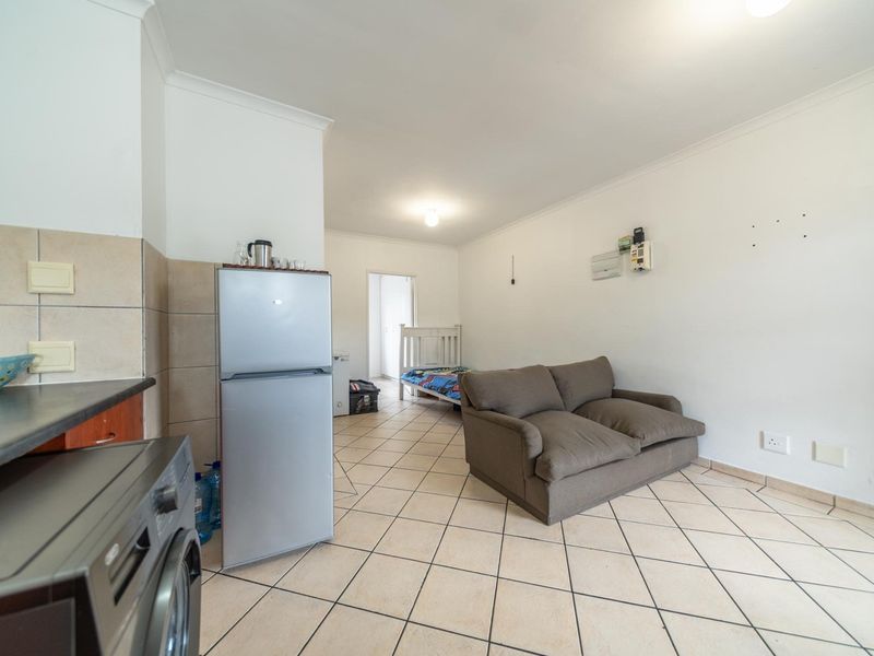 Open-plan living area featuring tiled flooring and a compact kitchen space, offering a functional layout for a studio or small apartment.